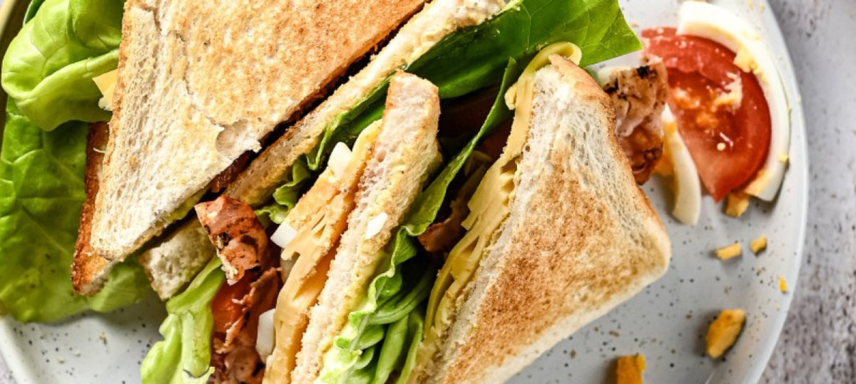 Club sandwich met Weydeland graskaas, bacon, ei en tomaat met een frisse salade
