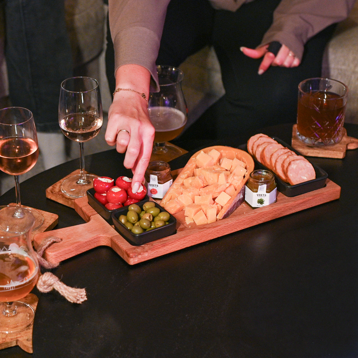 Gevulde borrelplank voor 2-3 personen op tafel met wijn en speciaalbier bij kaarslicht | Kaas & Borrelz