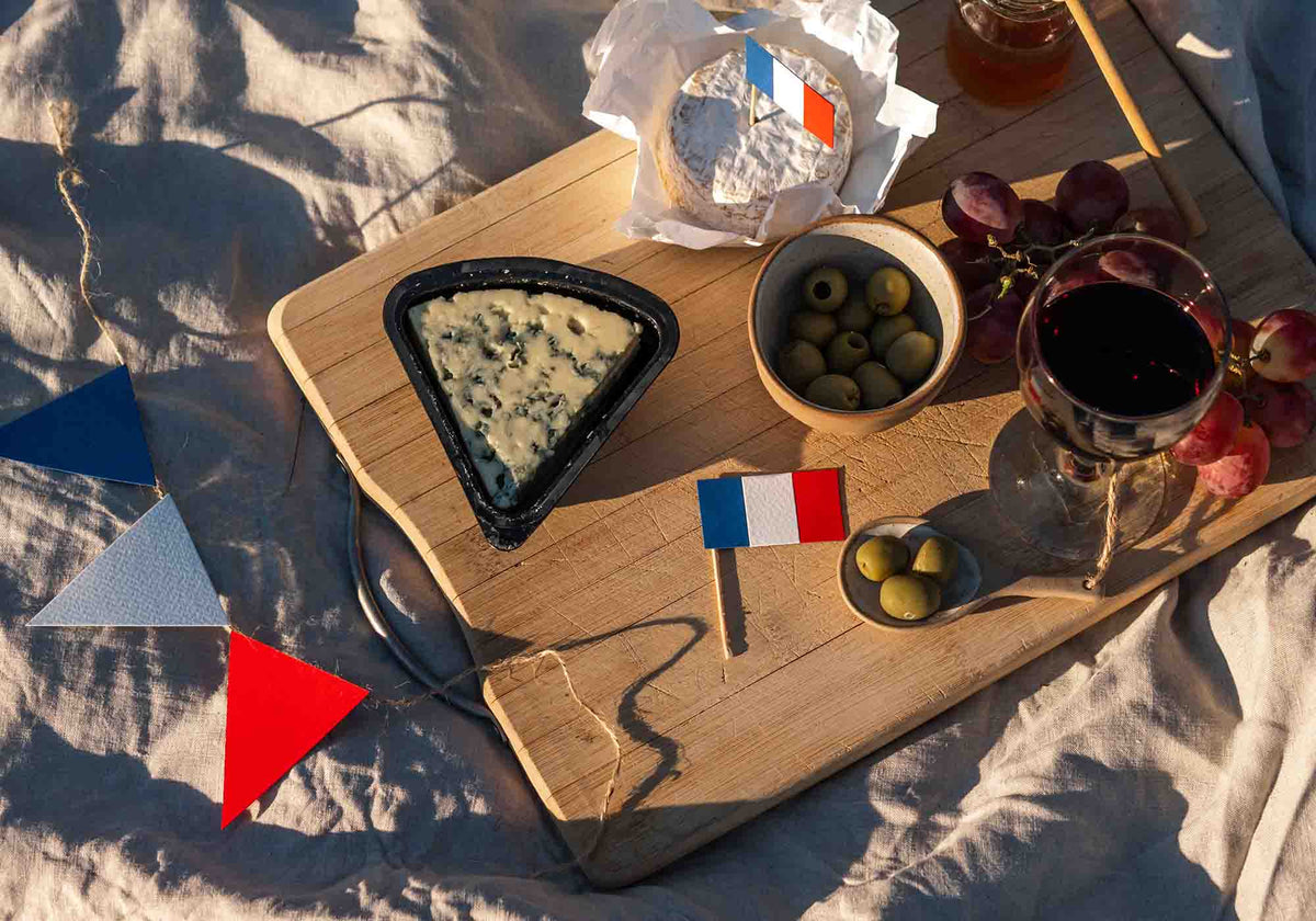 Plank met buitenlandse kazen, olijven en Franse vlaggetjes | Kaas & Borrelz