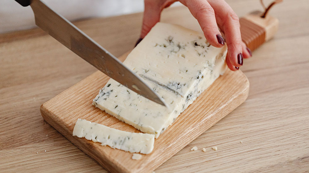 Chevretta Blue geitenkaas snijden op een plank | Kaas & Borrelz