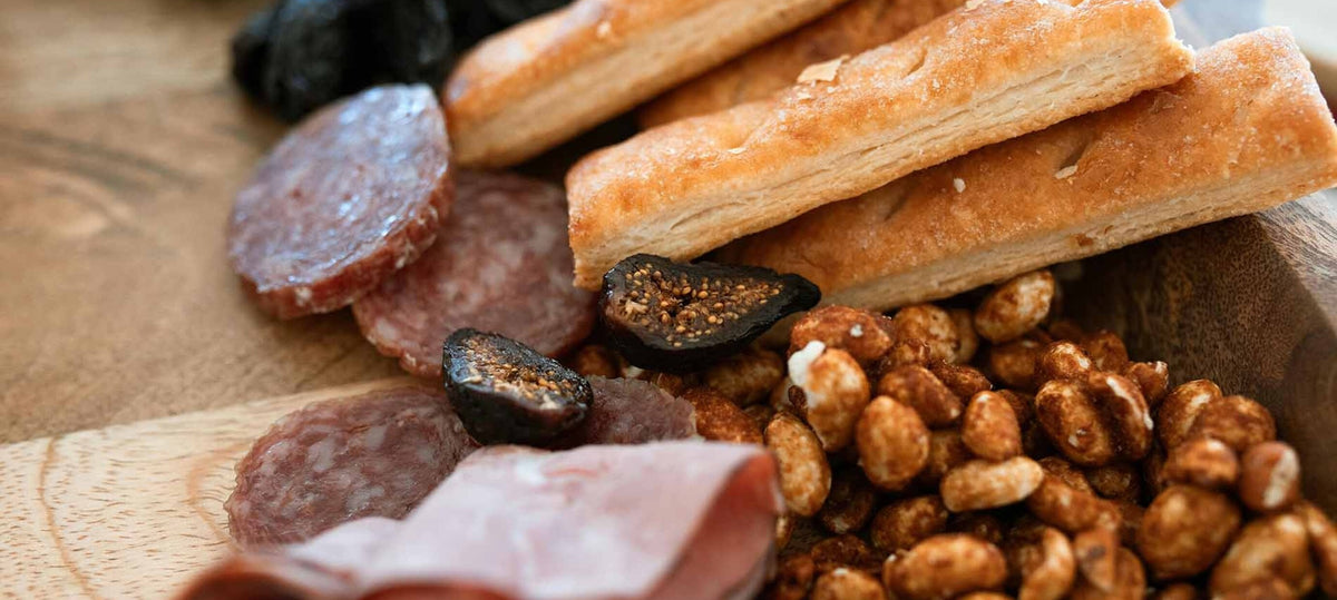 Gevulde borrelplank met kaas, worst, noten, fruit en dips