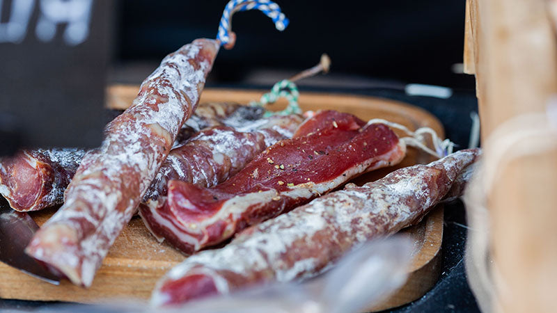 Gesneden charcuterie en droge worst op een houten plank | Kaas & Borrelz