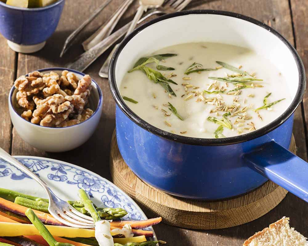 Geitenkaasfondue in een blauwe pan met noten en brood | Kaas & Borrelz