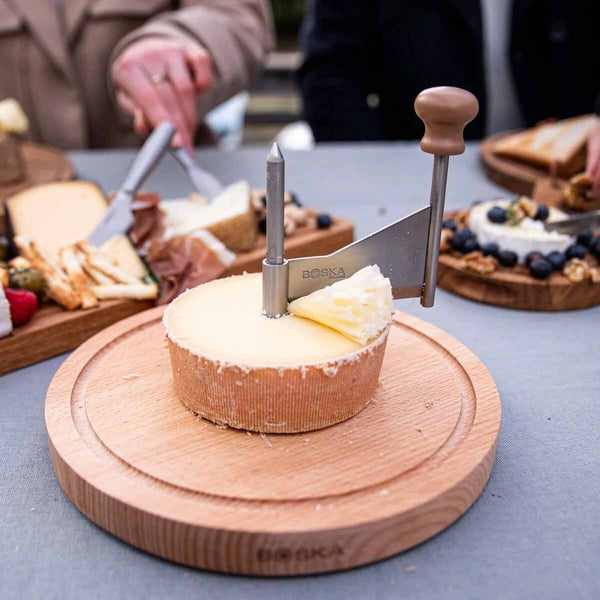 Boska kaaskruller met Tête de Moine op een gedekte tafel | Kaas & Borrelz