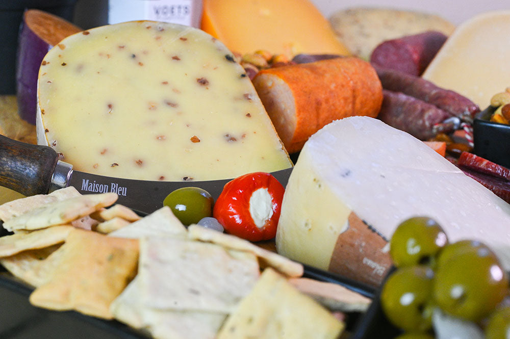Kruidenkazen op een plank met olijven en crackers | Kaas & Borrelz