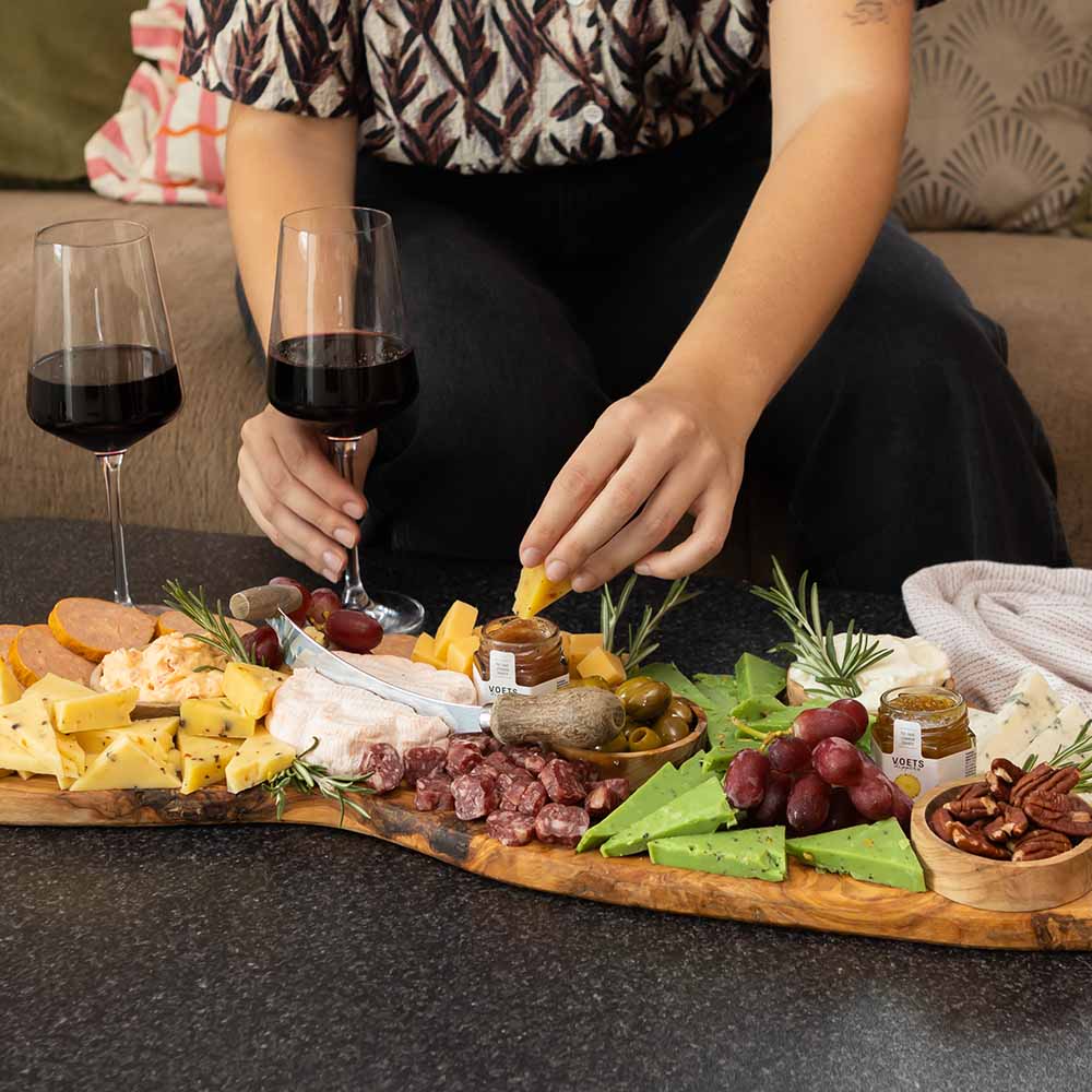 Borrelplank met kaas, worst en druiven bij een glas rode wijn | Kaas & Borrelz