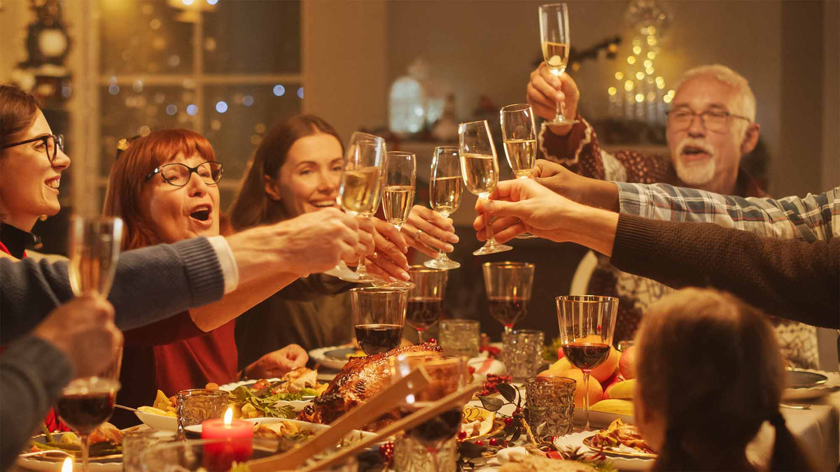 Familie proost aan een feestelijk gedekte tafel tijdens een gezellige borrel | Kaas & Borrelz